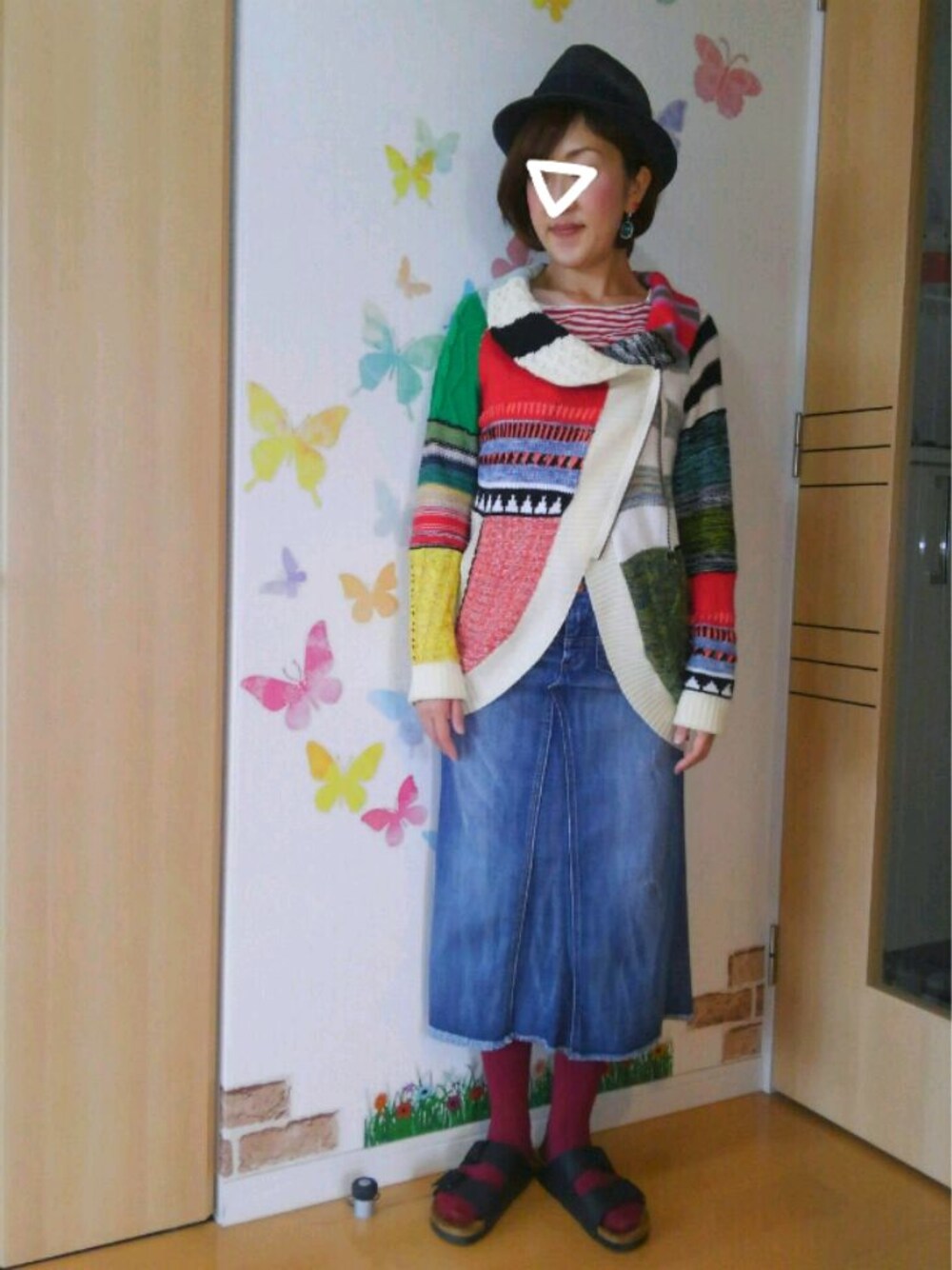 ホワイト系のニット/セーター、ブルー系のデニムスカート、ブラック系のサンダルを着用したレディースの夏コーディネートの1枚目の写真