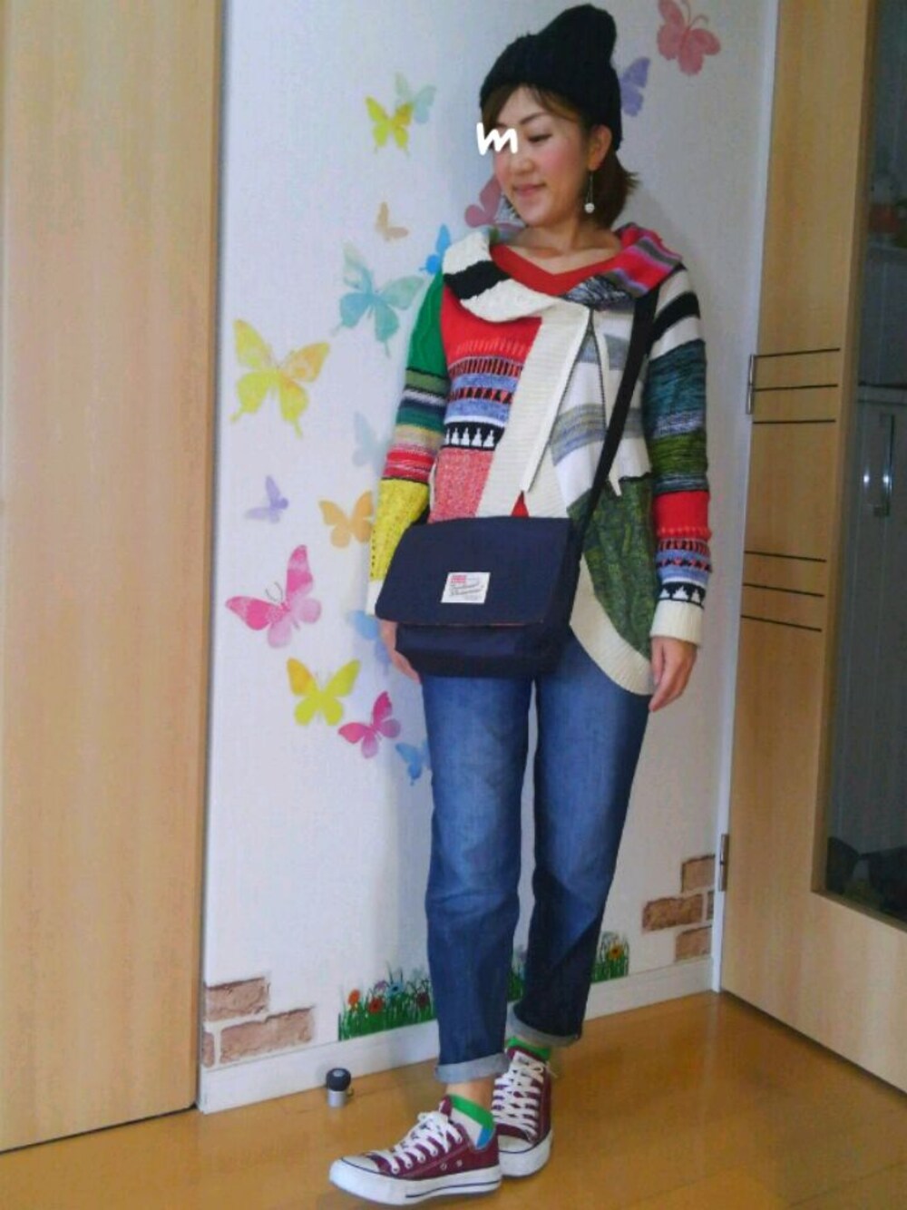 ホワイト系のカーディガン/ボレロ、オレンジ系のニット/セーター、ブルー系のデニムパンツを着用したレディースの秋コーディネートの1枚目の写真