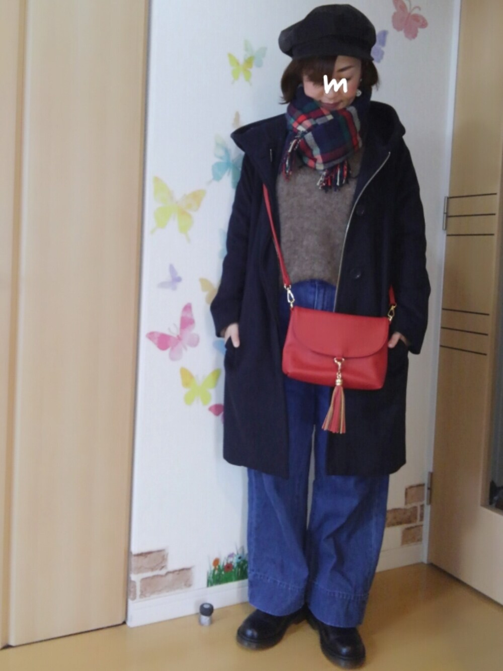 ブラック系のブーツ、レッド系のショルダーバッグ、ブルー系のデニムパンツを着用したレディースの冬コーディネートの1枚目の写真