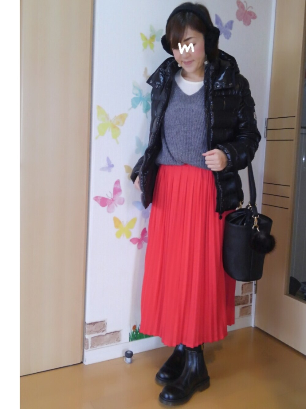 グレー系のニット/セーター、ブラック系のブーツ、レッド系のスカートを着用したレディースの冬コーディネートの1枚目の写真