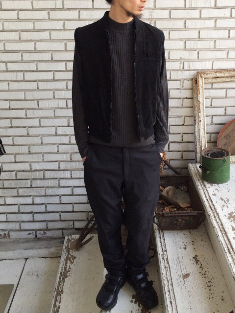 ブラック系のダウンベスト、グレー系のスウェット、ブラック系のスラックスを着用したメンズの冬コーディネートの1枚目の写真