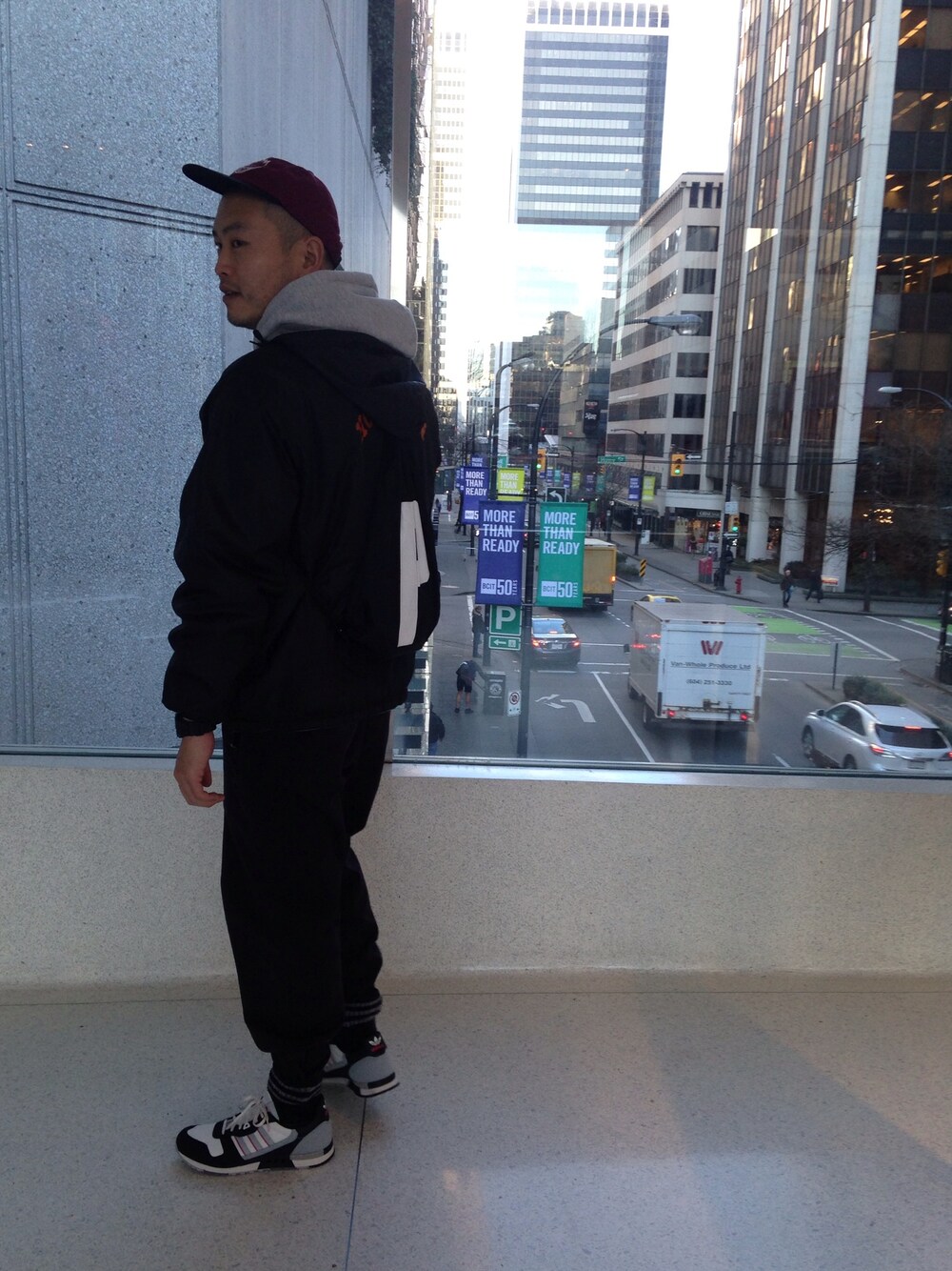 ブラック系のスニーカー、レッド系のキャップを着用したメンズの冬コーディネートの1枚目の写真