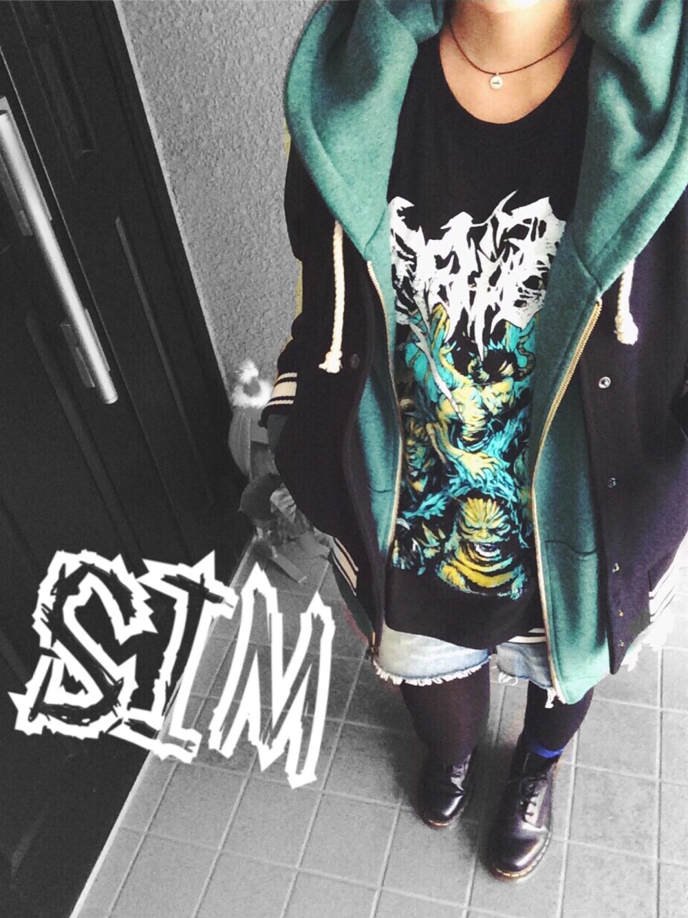 ブラック系のTシャツ/カットソー、ブルー系のデニムスカート、ブラック系のブーツを着用したレディースの冬コーディネートの1枚目の写真