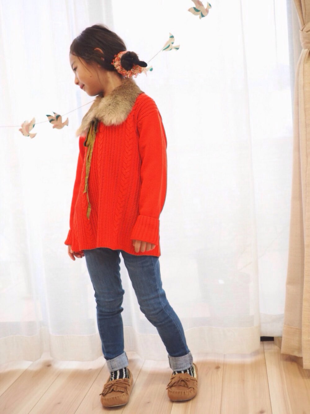 オレンジ系のニット/セーター、ブルー系のデニムパンツ、ベージュ系のモカシン/デッキシューズを着用したキッズの秋コーディネートの1枚目の写真