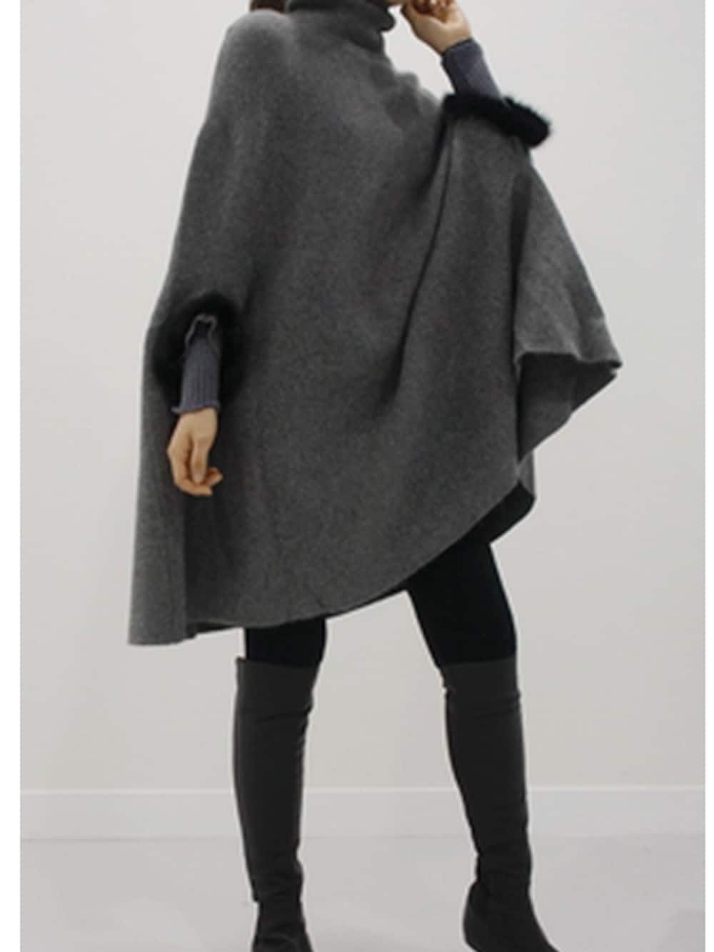 グレー系のポンチョを着用したレディースの冬コーディネートの1枚目の写真