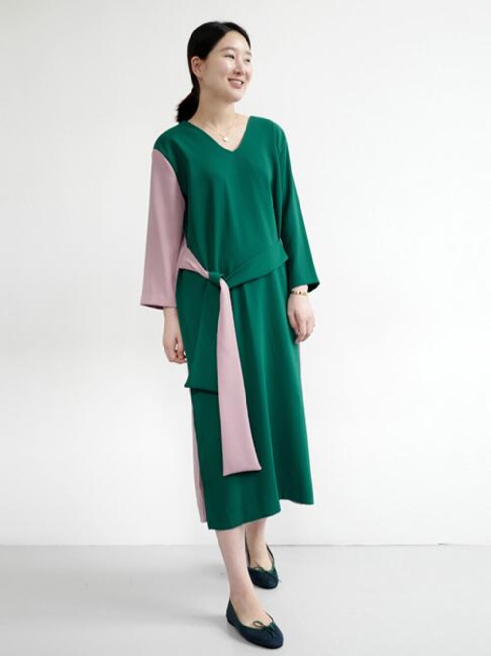 グリーン系のワンピースを着用したレディースの秋コーディネートの1枚目の写真