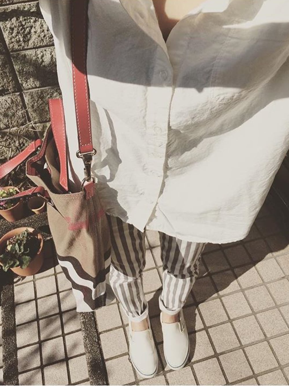 ホワイト系のスニーカー、グレー系のデニムパンツ、ホワイト系のシャツ/ブラウスを着用したレディースの秋コーディネートの1枚目の写真