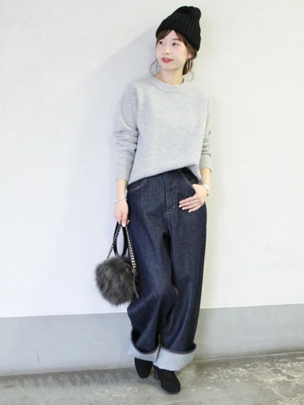 ブルー系のデニムパンツ、グレー系のニット/セーター、ブラック系のショルダーバッグを着用したレディースの秋コーディネートの1枚目の写真