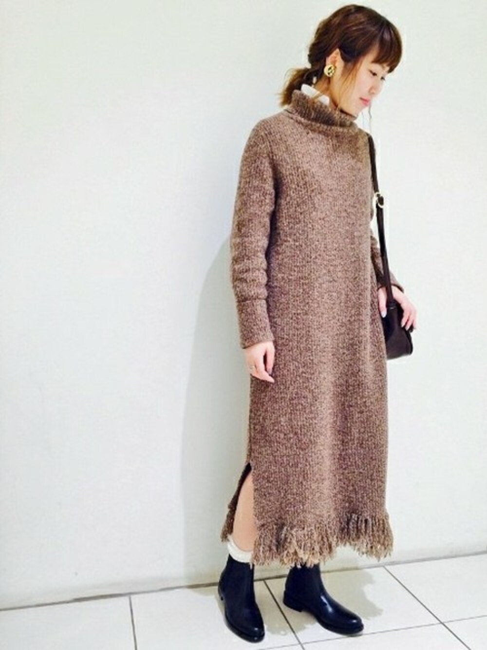 ブラウン系のワンピース、ホワイト系のシャツワンピース、ブラック系のブーツを着用したレディースの冬コーディネートの1枚目の写真