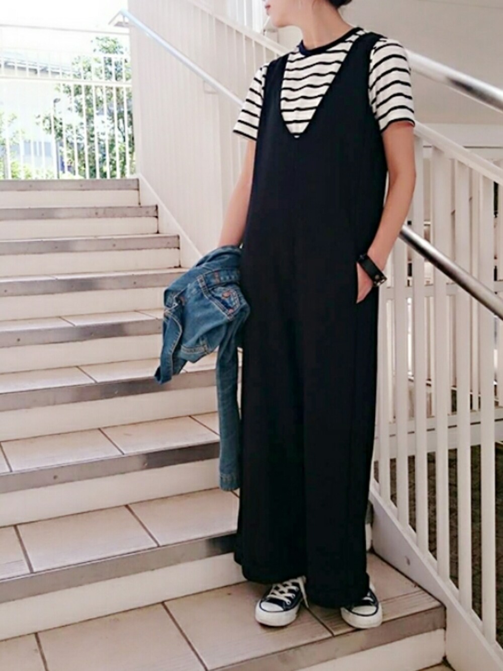 ブラック系のサロペット/オーバーオール、ホワイト系のTシャツ/カットソー、ブルー系のデニムジャケットを着用したレディースの春コーディネートの1枚目の写真