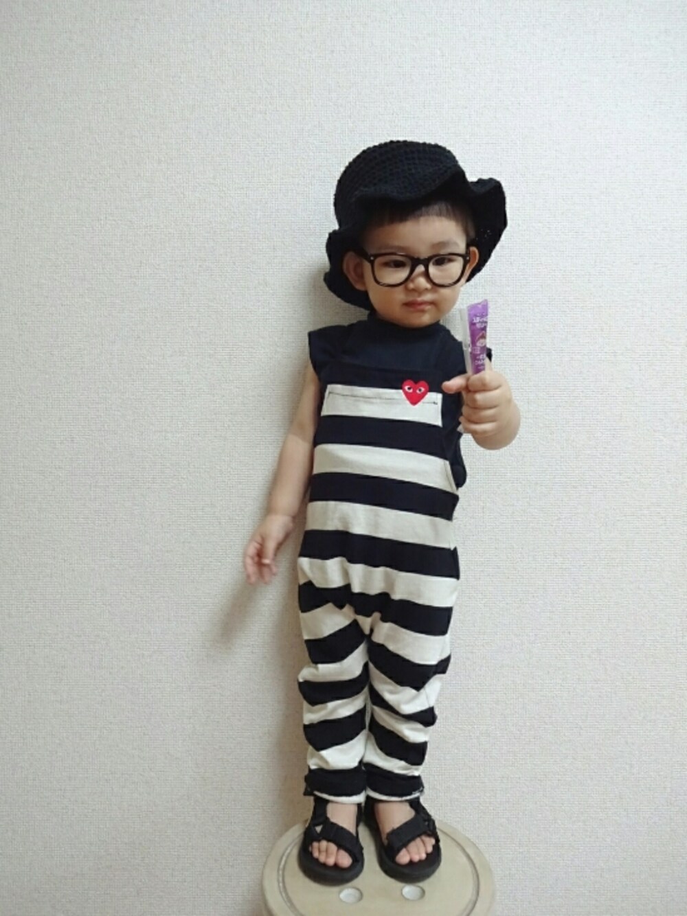 ブラック系のオールインワン・サロペット、ブラック系のサンダル、ブルー系のTシャツ/カットソーを着用したキッズの夏コーディネートの1枚目の写真