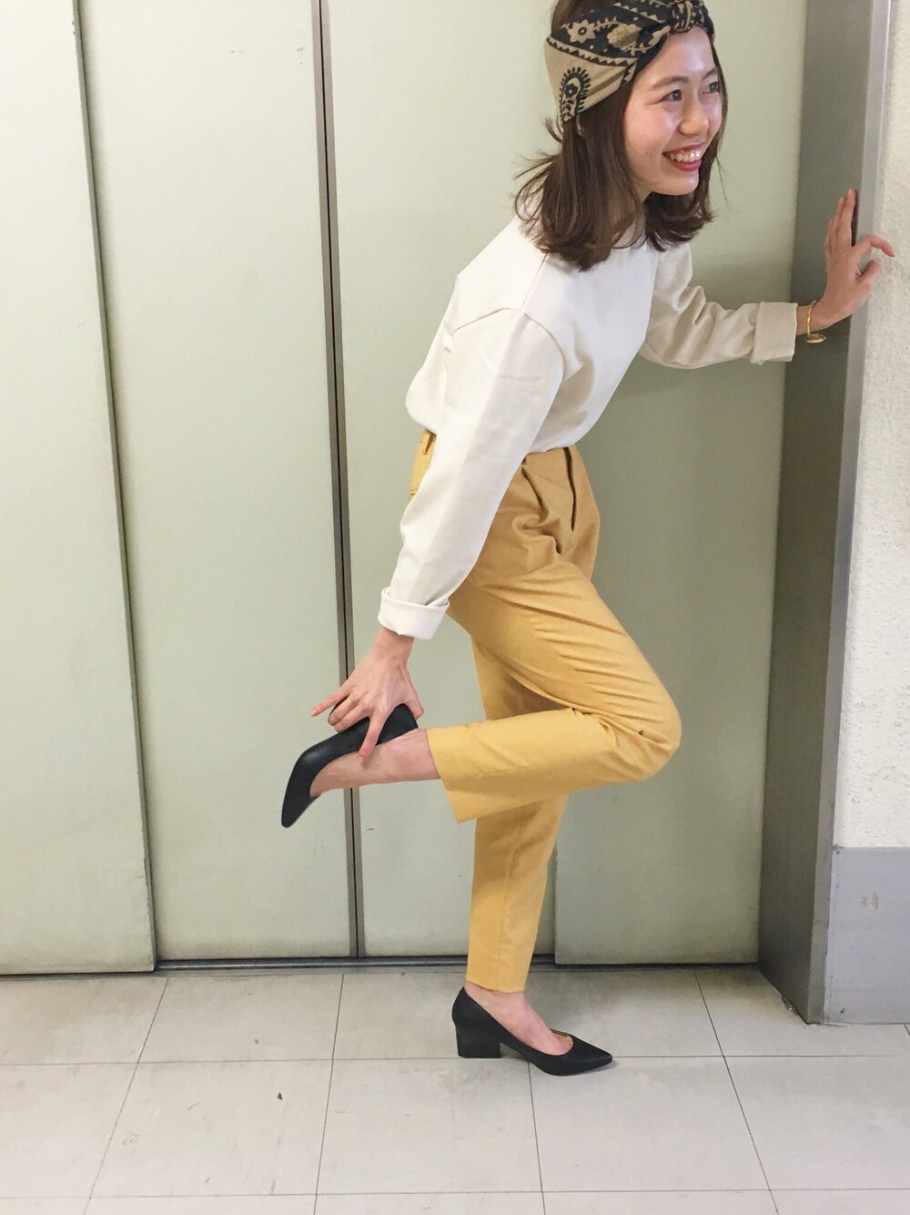 イエロー系のその他パンツ、ブラック系のパンプス、ホワイト系のトップスを着用したレディースの春コーディネートの1枚目の写真