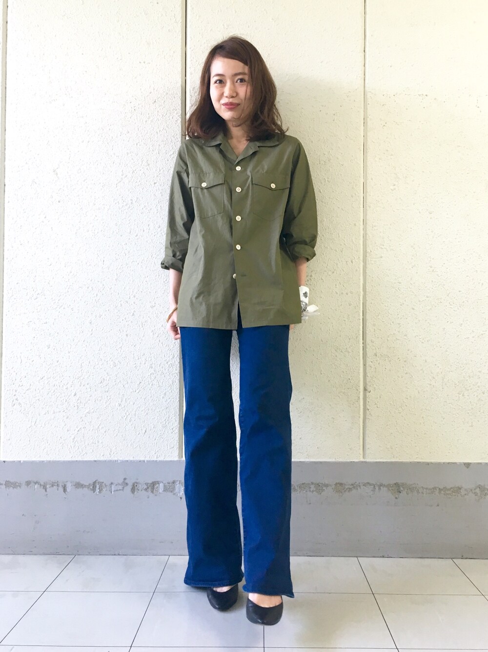 ブルー系のデニムパンツ、ブラック系のパンプス、グリーン系のシャツ/ブラウスを着用したレディースの春コーディネートの1枚目の写真