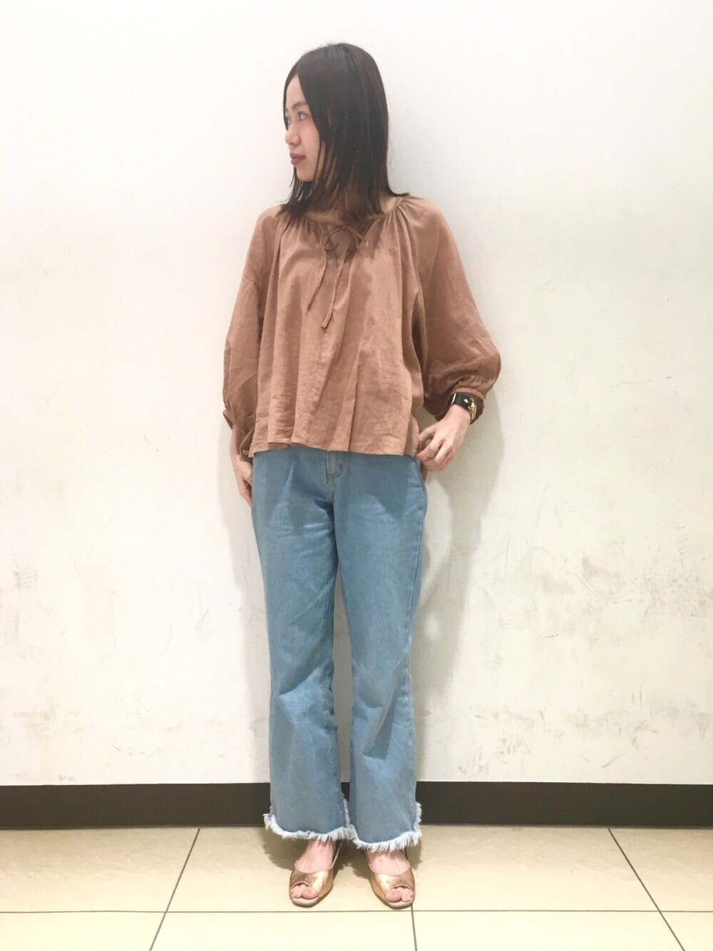 ベージュ系のシャツ/ブラウス、ブルー系のデニムパンツ、ゴールド系のイヤリングを着用したレディースの春コーディネートの1枚目の写真