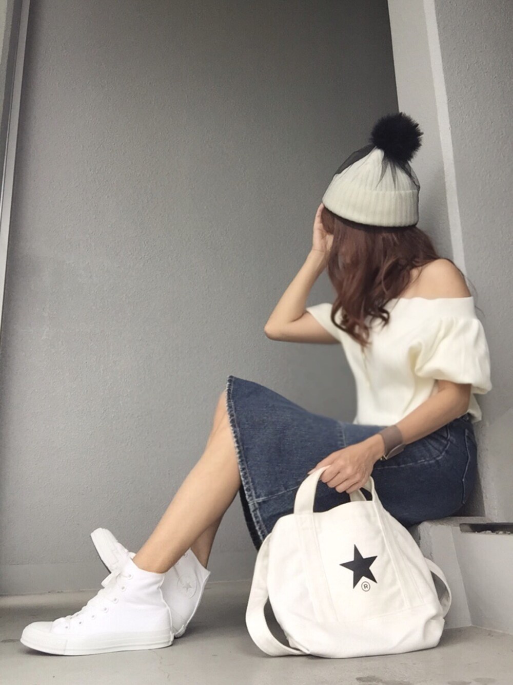 ホワイト系のTシャツ/カットソー、ブルー系のデニムスカート、ホワイト系のスニーカーを着用したレディースの秋コーディネートの1枚目の写真