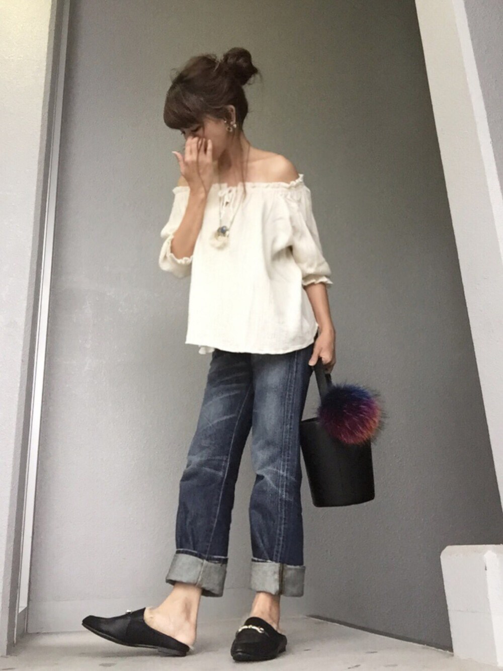 ホワイト系のトップス、ブルー系のデニムパンツ、ブラック系のトートバッグを着用したレディースの秋コーディネートの1枚目の写真