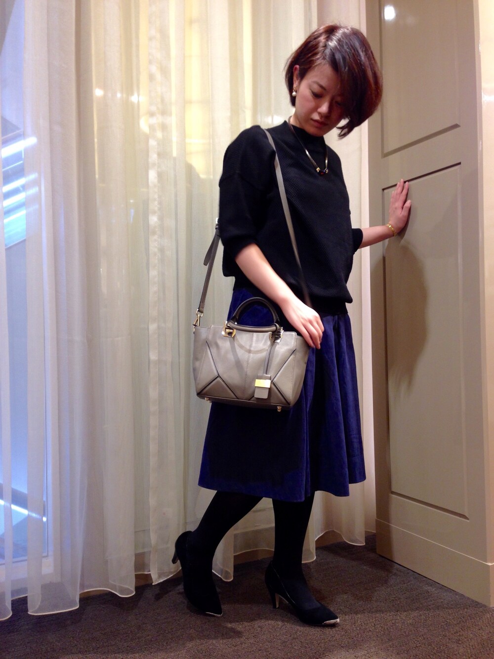 グレー系のトートバッグ、ブラック系のパンプスを着用したレディースの秋コーディネートの1枚目の写真