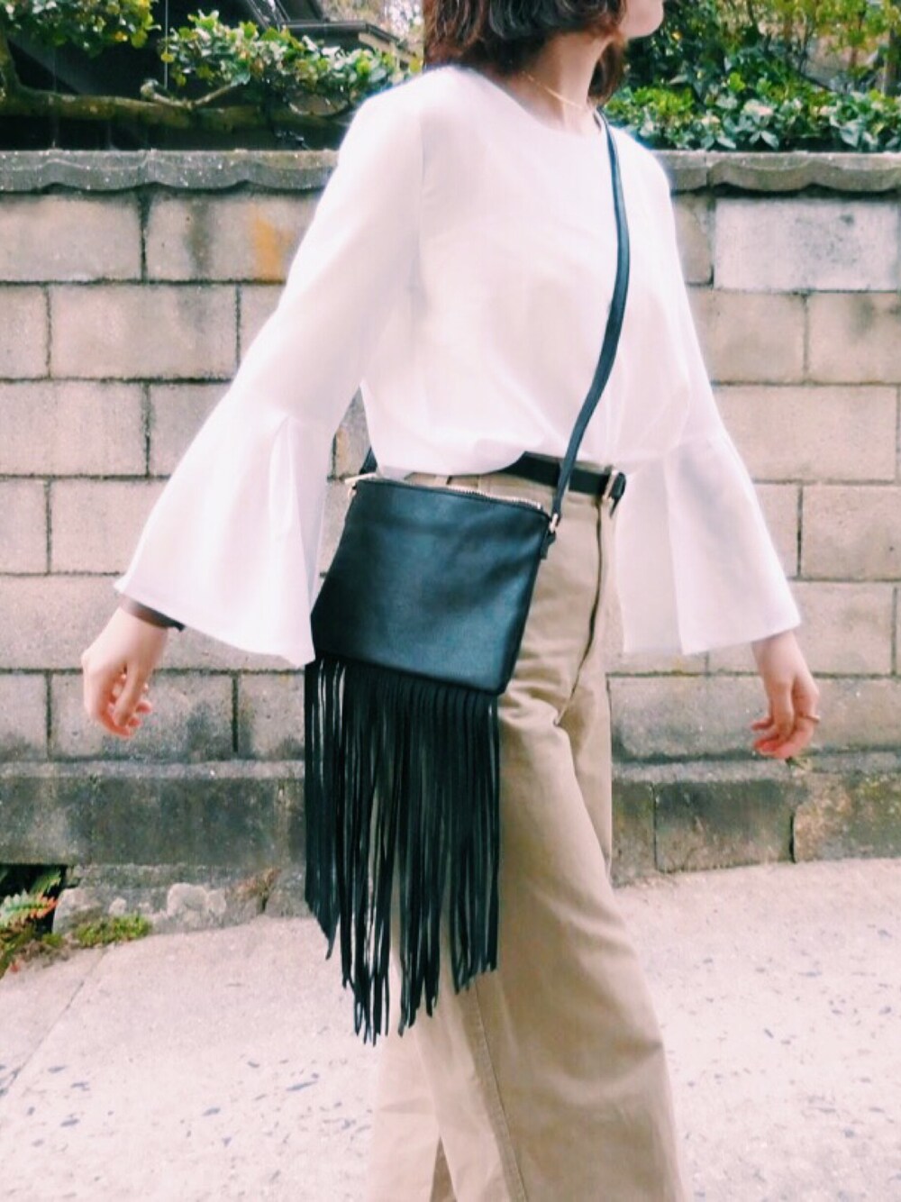 ホワイト系のシャツ/ブラウス、ベージュ系のチノパンツ、ブラック系のショルダーバッグを着用したレディースの春コーディネートの1枚目の写真