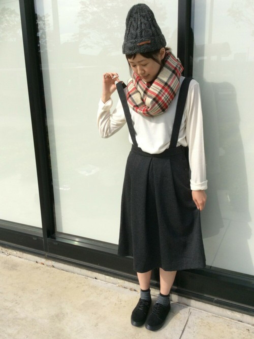 ブラウン系のスカート、ホワイト系のTシャツ/カットソー、ブラック系のスニーカーを着用したレディースの秋コーディネートの1枚目の写真