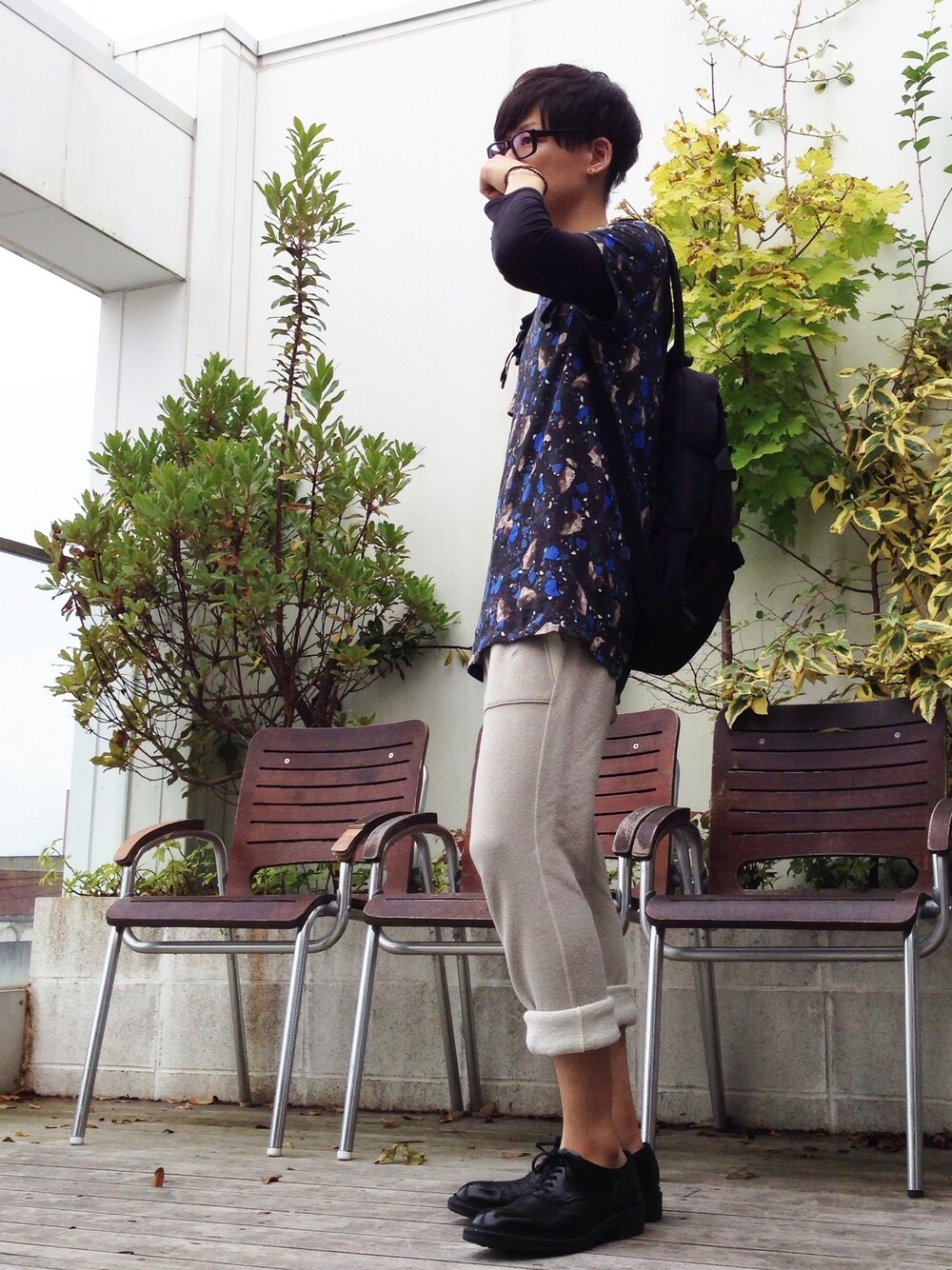 「スウェットパンツ、バックパック、ブレスレット、革靴、ロールアップ、黒縁メガネ、総柄Tシャツ、鼻すすってる訳じゃあありませんよ？」｜「ACNEのStandard Print（Tシャツ/カットソー、その他）」を使った、yuさん（メンズ・177cm）の秋コーディネートの1枚目の写真