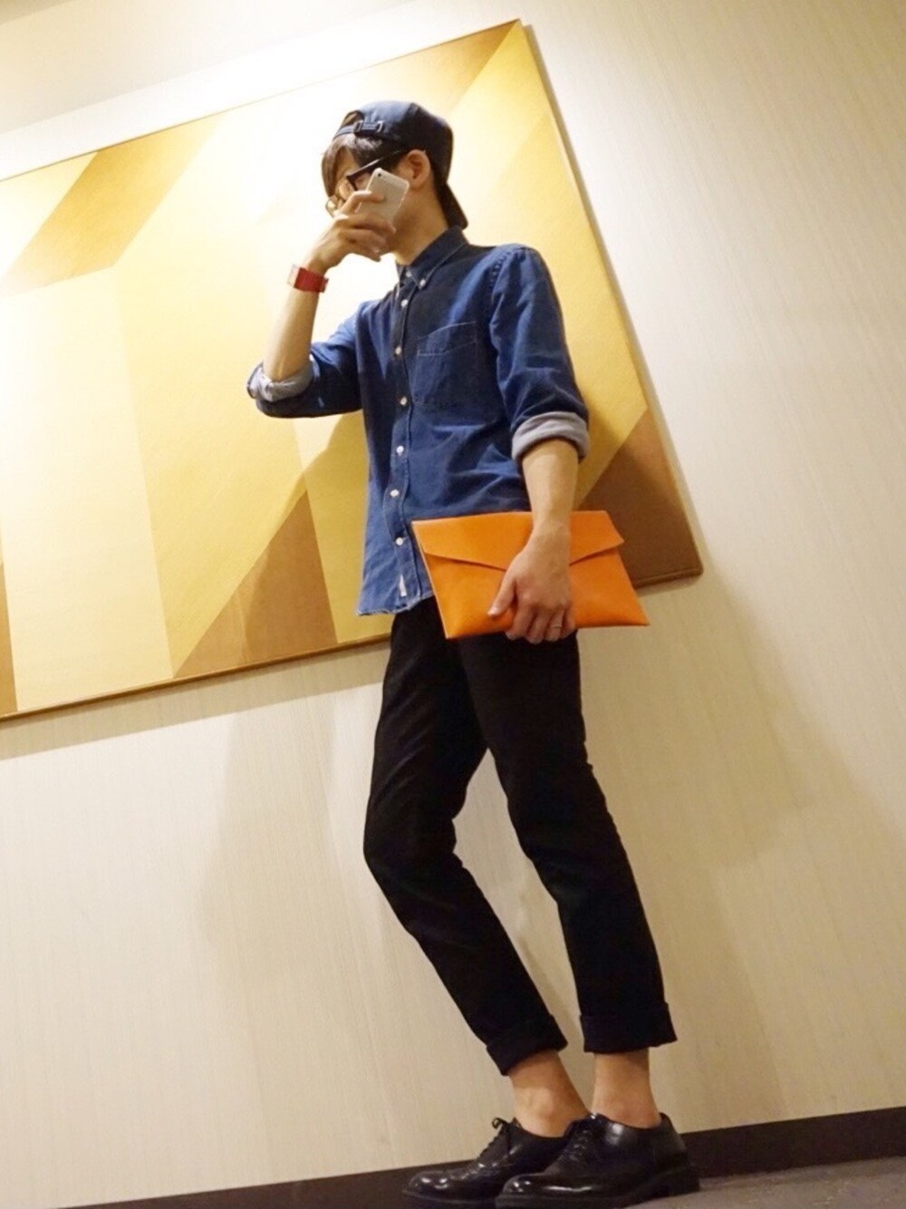 「クラッチバッグ、デニムシャツ、革靴、ロールアップ、黒縁メガネ」｜「Acne StudiosのAcne Studios Isherwood Button-Down Collar Denim Shirt（シャツ/ブラウス、ブルー系）」を使った、yuさん（メンズ・177cm）の秋コーディネートの1枚目の写真