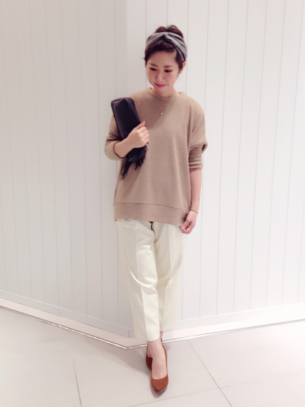 ホワイト系のその他パンツ、ベージュ系のパンプス、ブラウン系のクラッチバッグを着用したレディースの秋コーディネートの1枚目の写真