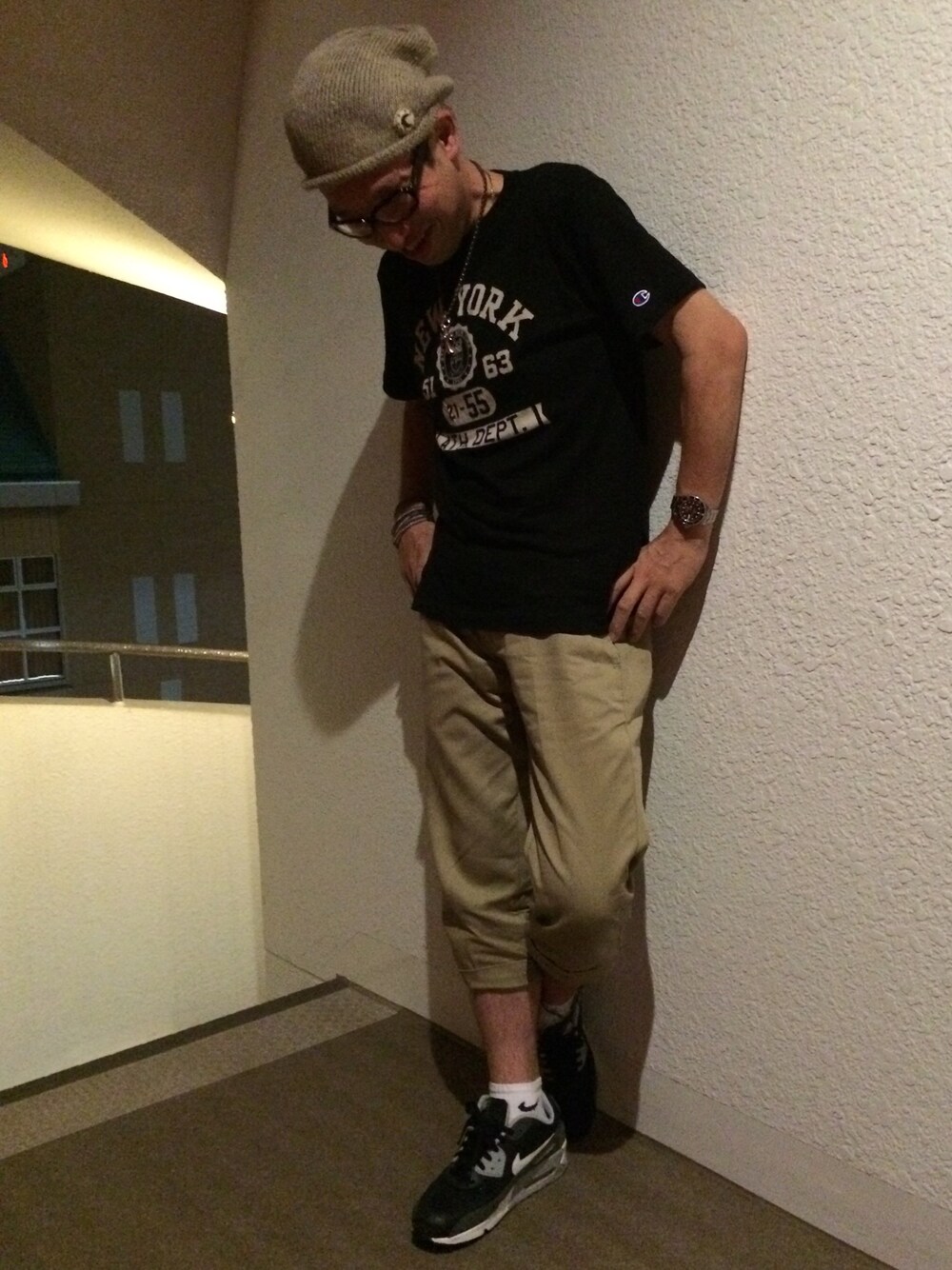 ブラウン系のチノパンツ、ブラック系のスニーカー、グリーン系のニットキャップ/ビーニーを着用したメンズの夏コーディネートの1枚目の写真