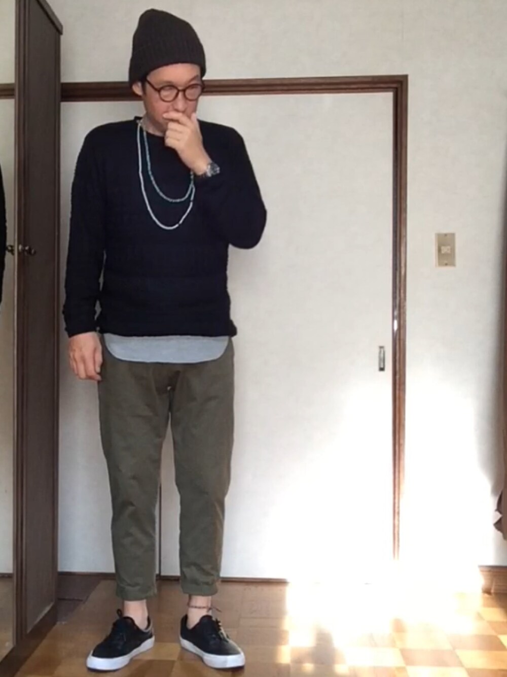 ブルー系のニット/セーター、グレー系のTシャツ/カットソー、グリーン系のチノパンツを着用したメンズの秋コーディネートの1枚目の写真