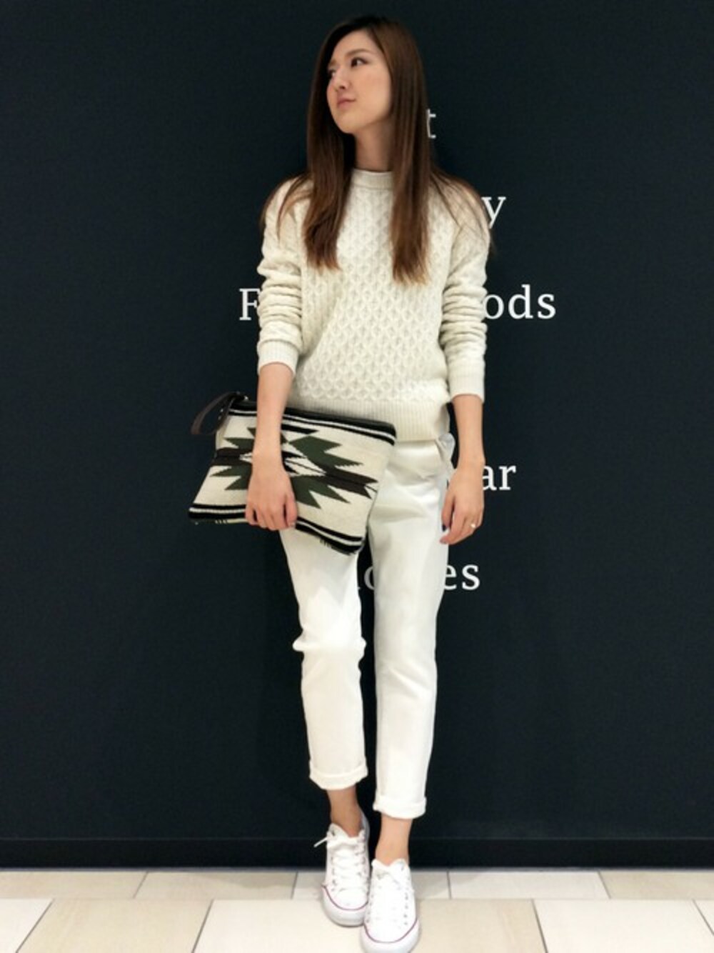 ホワイト系のニット/セーター、グレー系のその他パンツ、グリーン系のクラッチバッグを着用したレディースの秋コーディネートの1枚目の写真