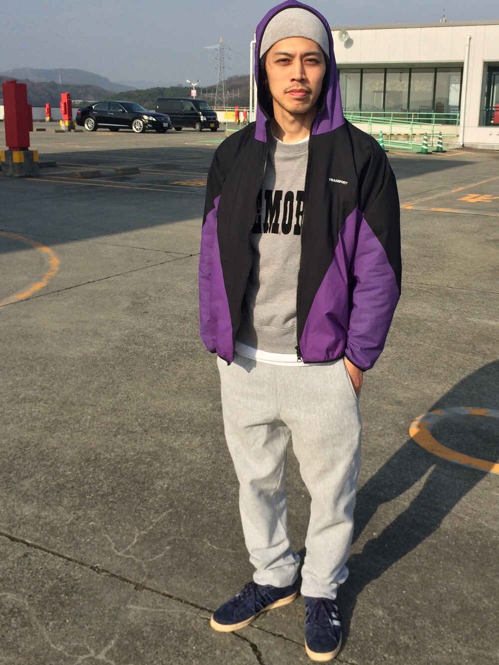 パープル系のナイロンジャケット、グレー系のスウェット、グレー系のその他パンツを着用したメンズの冬コーディネートの1枚目の写真