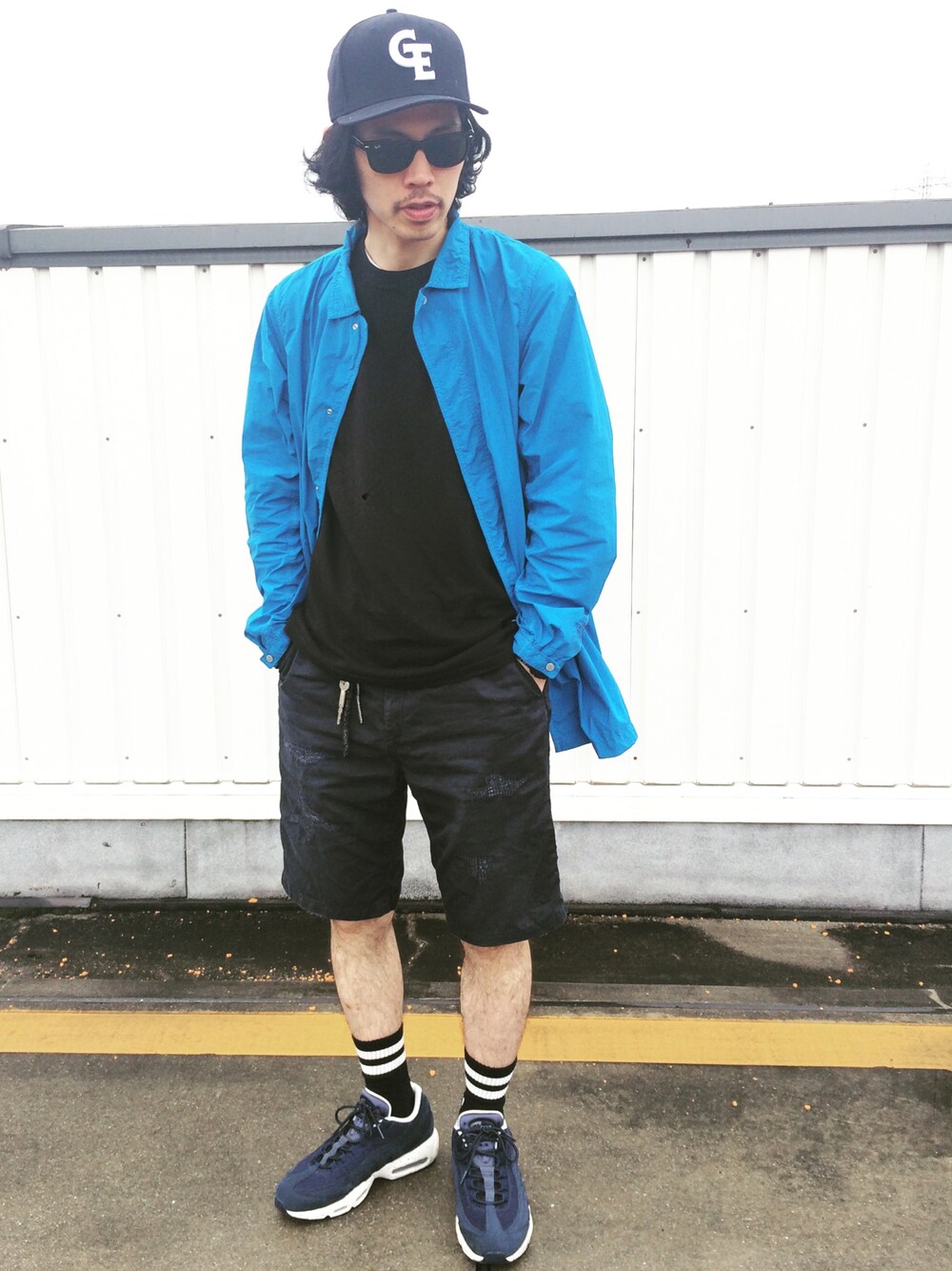 ブルー系のステンカラーコート、ブラック系のTシャツ/カットソー、ブルー系のパンツを着用したメンズの春コーディネートの1枚目の写真