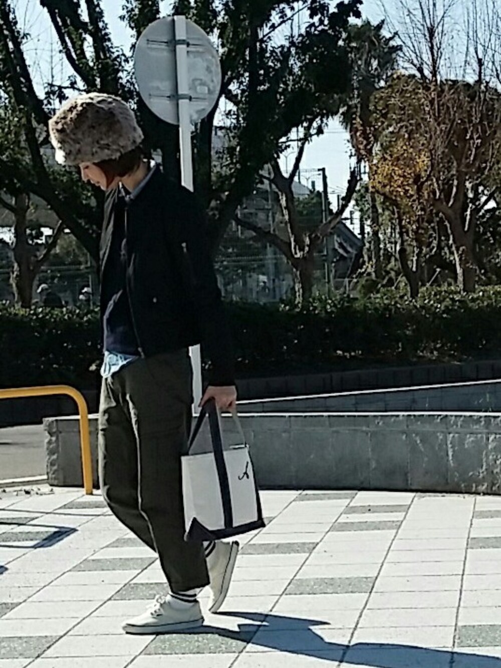 グリーン系のブルゾン、ブルー系のトートバッグ、ベージュ系の帽子を着用したレディースの冬コーディネートの1枚目の写真