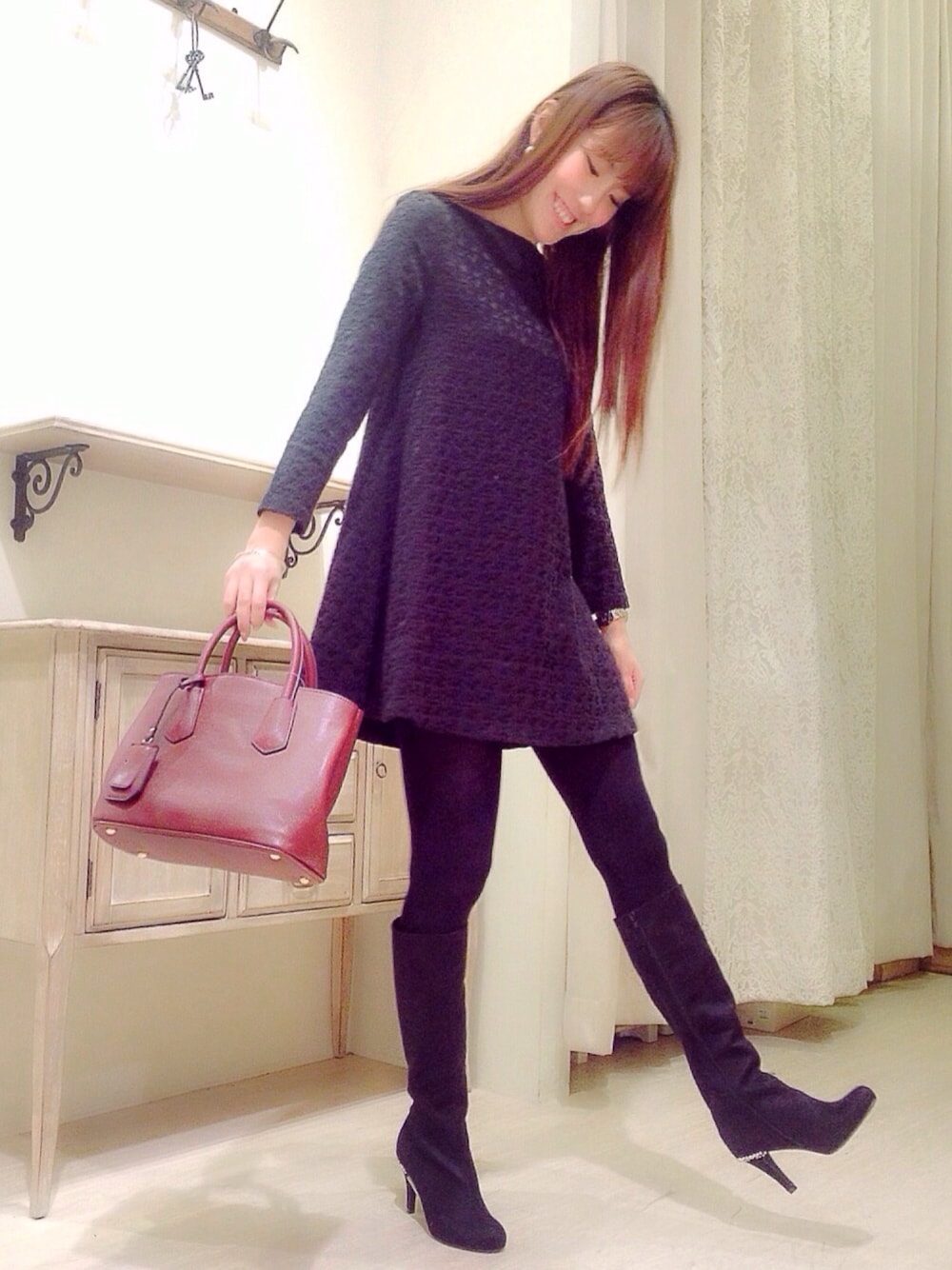 ブラック系のワンピース、レッド系のトートバッグ、ブラック系のブーツを着用したレディースの秋コーディネートの1枚目の写真