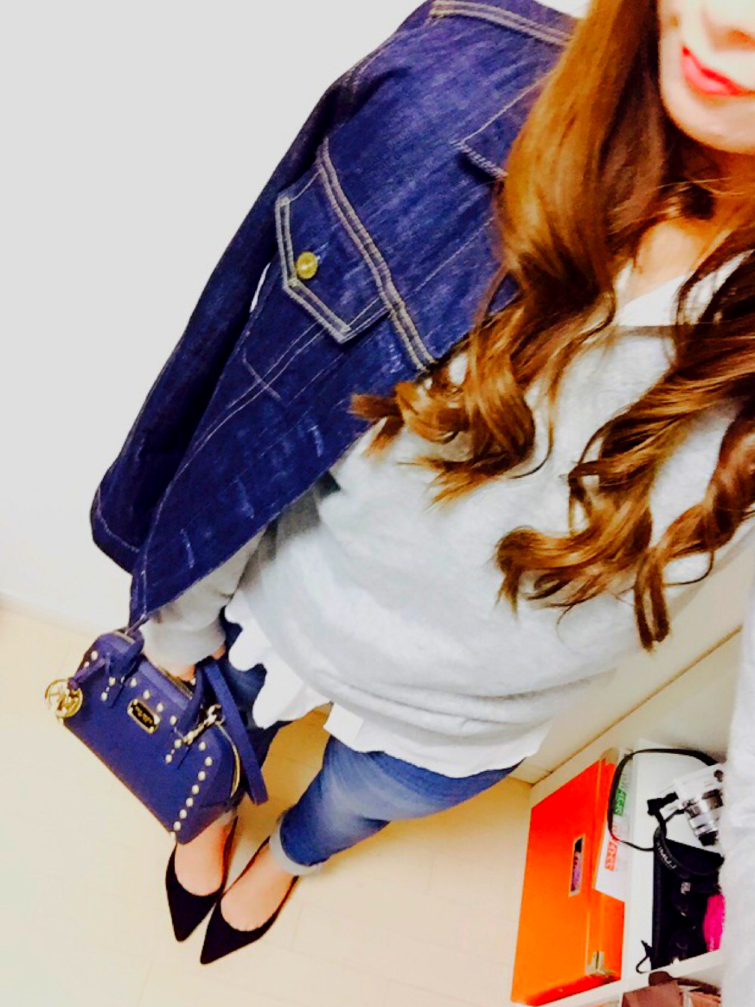 ブルー系のデニムジャケット、グレー系のニット/セーター、ホワイト系のシャツ/ブラウスを着用したレディースの冬コーディネートの1枚目の写真