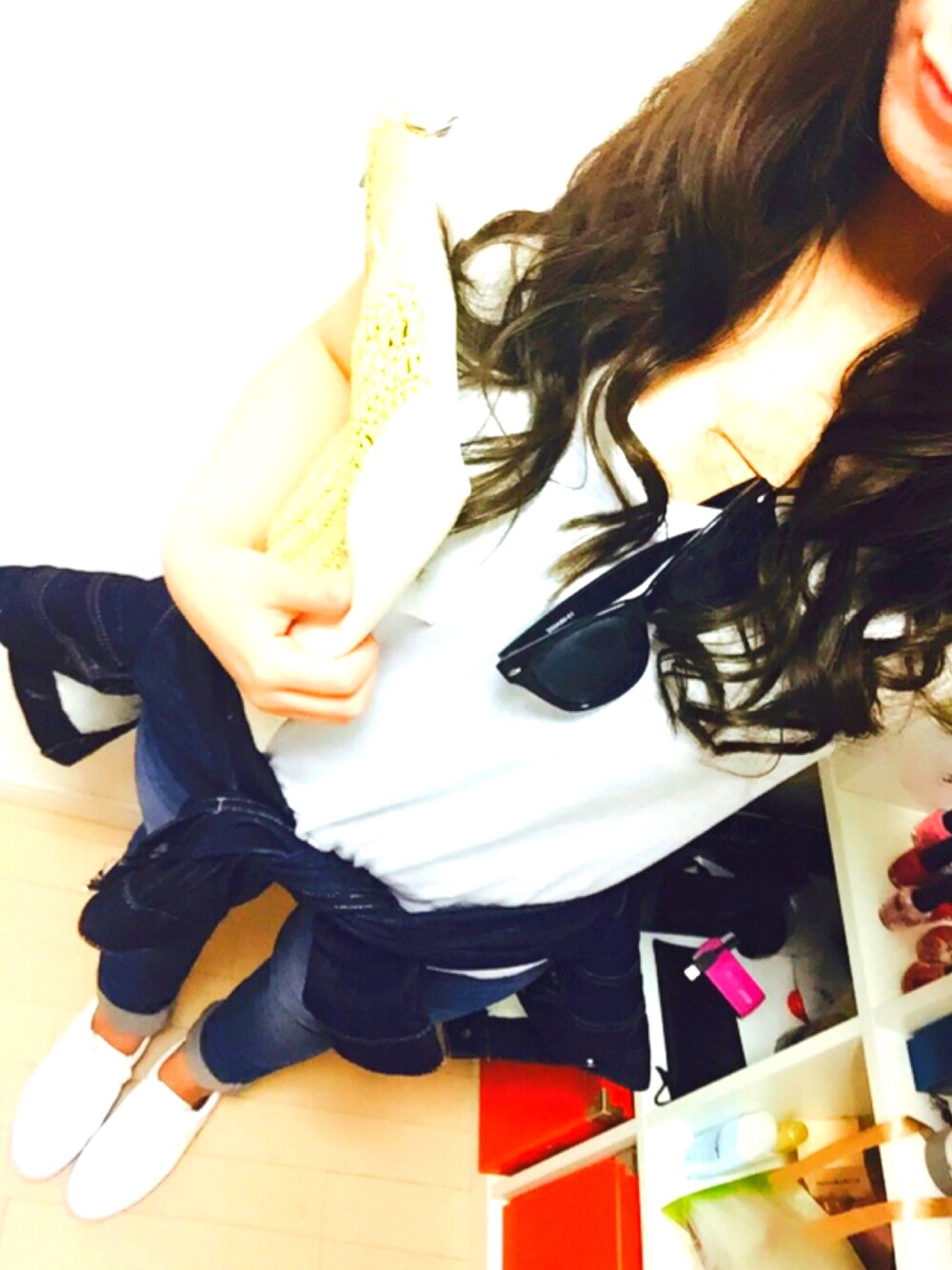 ホワイト系のTシャツ/カットソー、ブルー系のデニムパンツ、ベージュ系のクラッチバッグを着用したレディースの春コーディネートの1枚目の写真