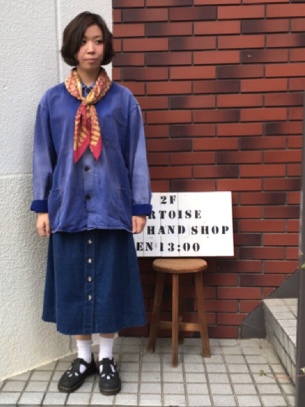 ブルー系のミリタリージャケット、ブルー系のデニムスカートを着用したレディースの春コーディネートの1枚目の写真