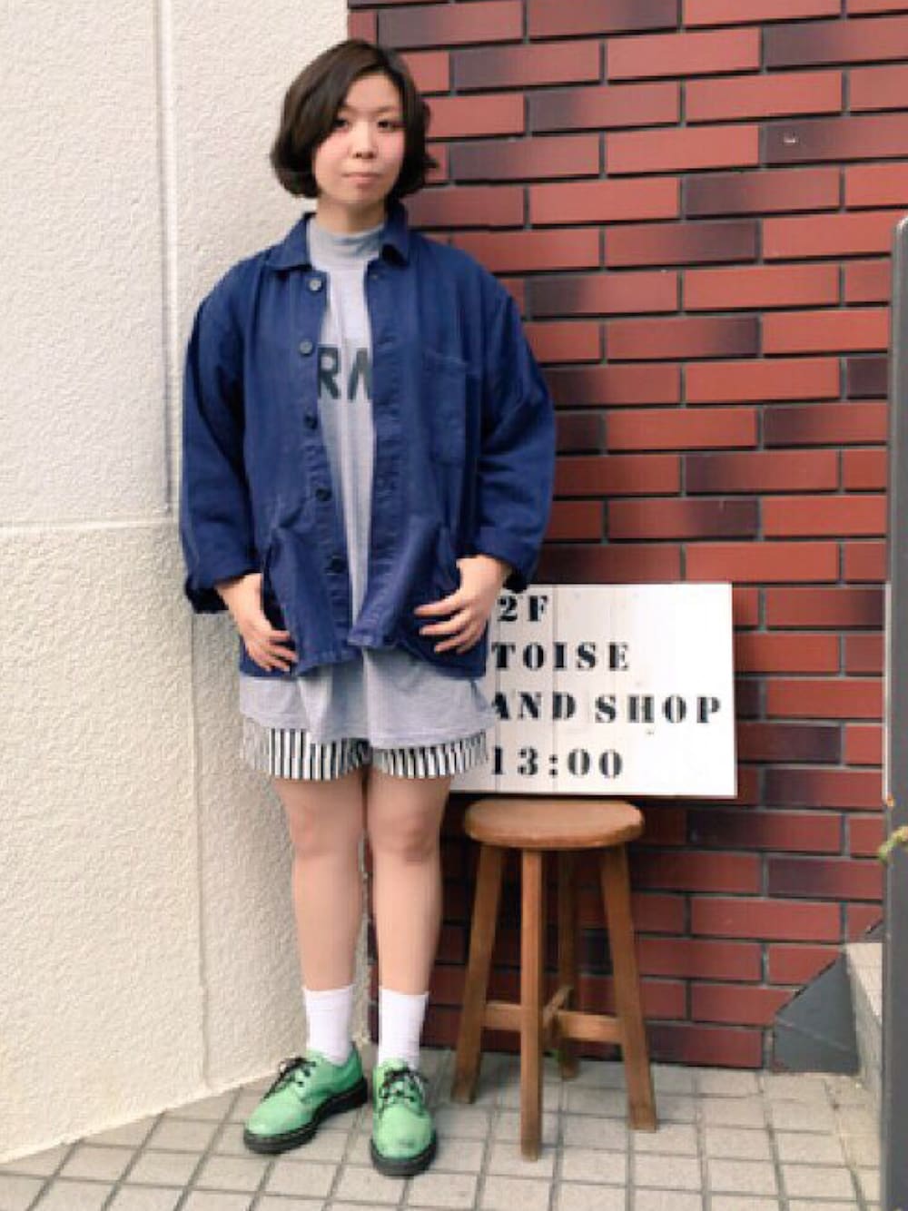 ブルー系のミリタリージャケット、グレー系のTシャツ/カットソー、グリーン系のブーツを着用したレディースの春コーディネートの1枚目の写真