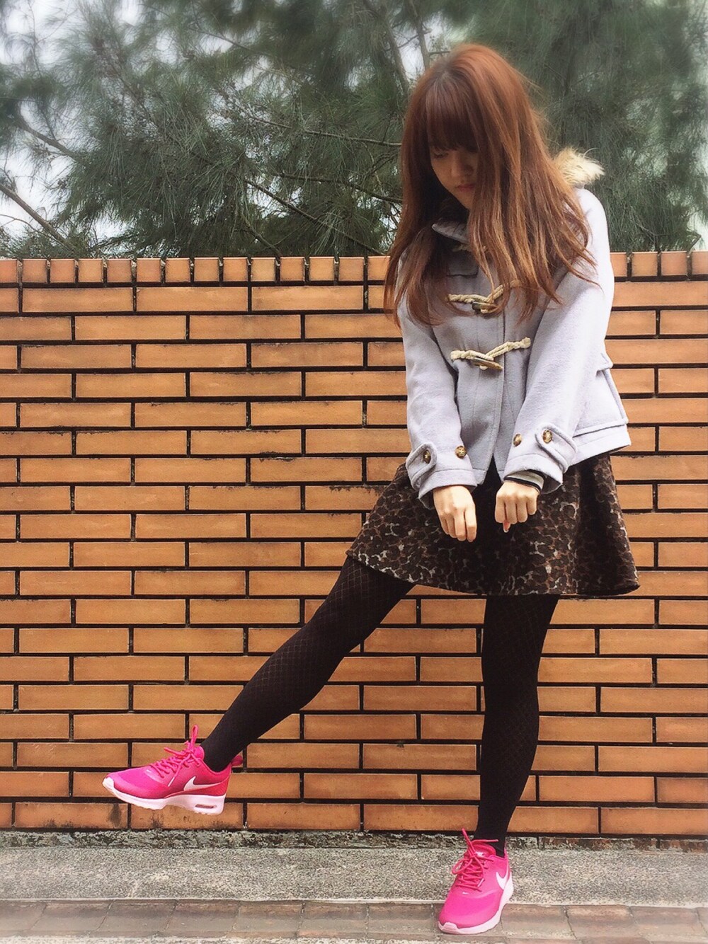 ピンク系のスニーカー、ブラウン系のスカート、ブルー系のダッフルコートを着用したレディースの冬コーディネートの1枚目の写真