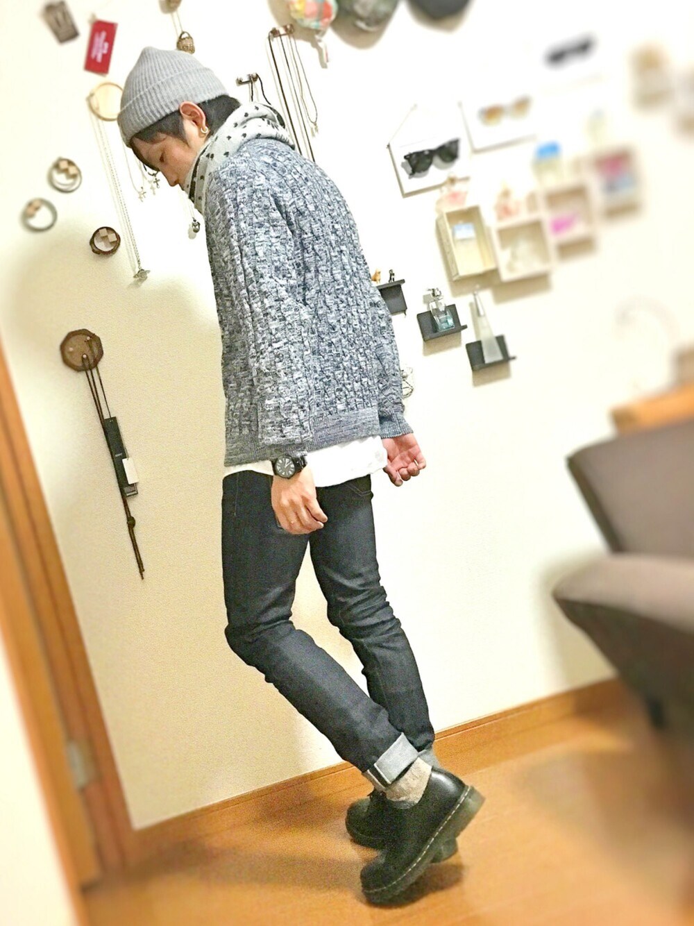 ブルー系のデニムパンツ、ブルー系のニット/セーター、ブラック系のブーツを着用したメンズの春コーディネートの1枚目の写真