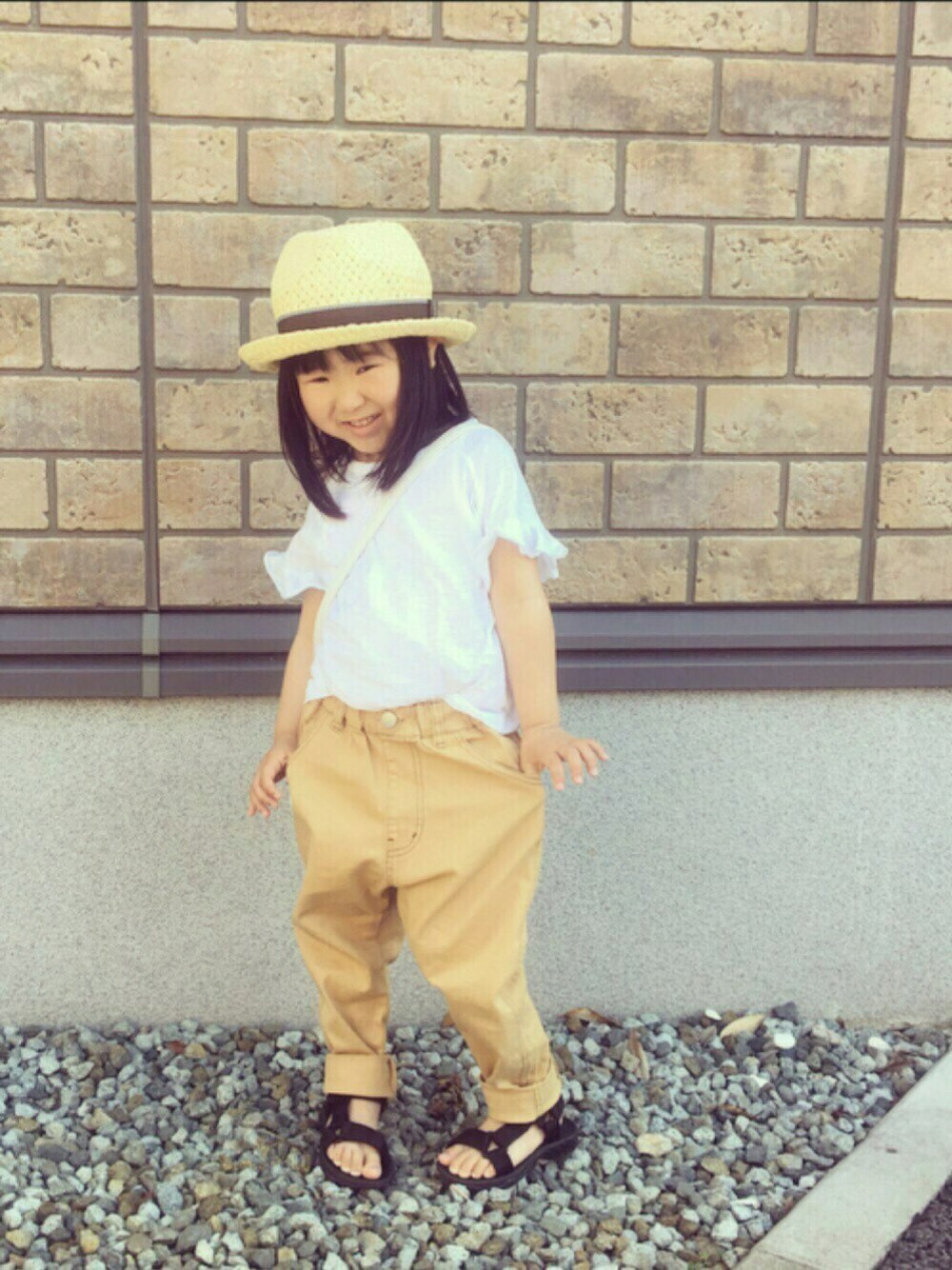 ベージュ系のその他パンツ、ホワイト系のショルダーバッグ、ホワイト系のTシャツ/カットソーを着用したキッズの春コーディネートの1枚目の写真