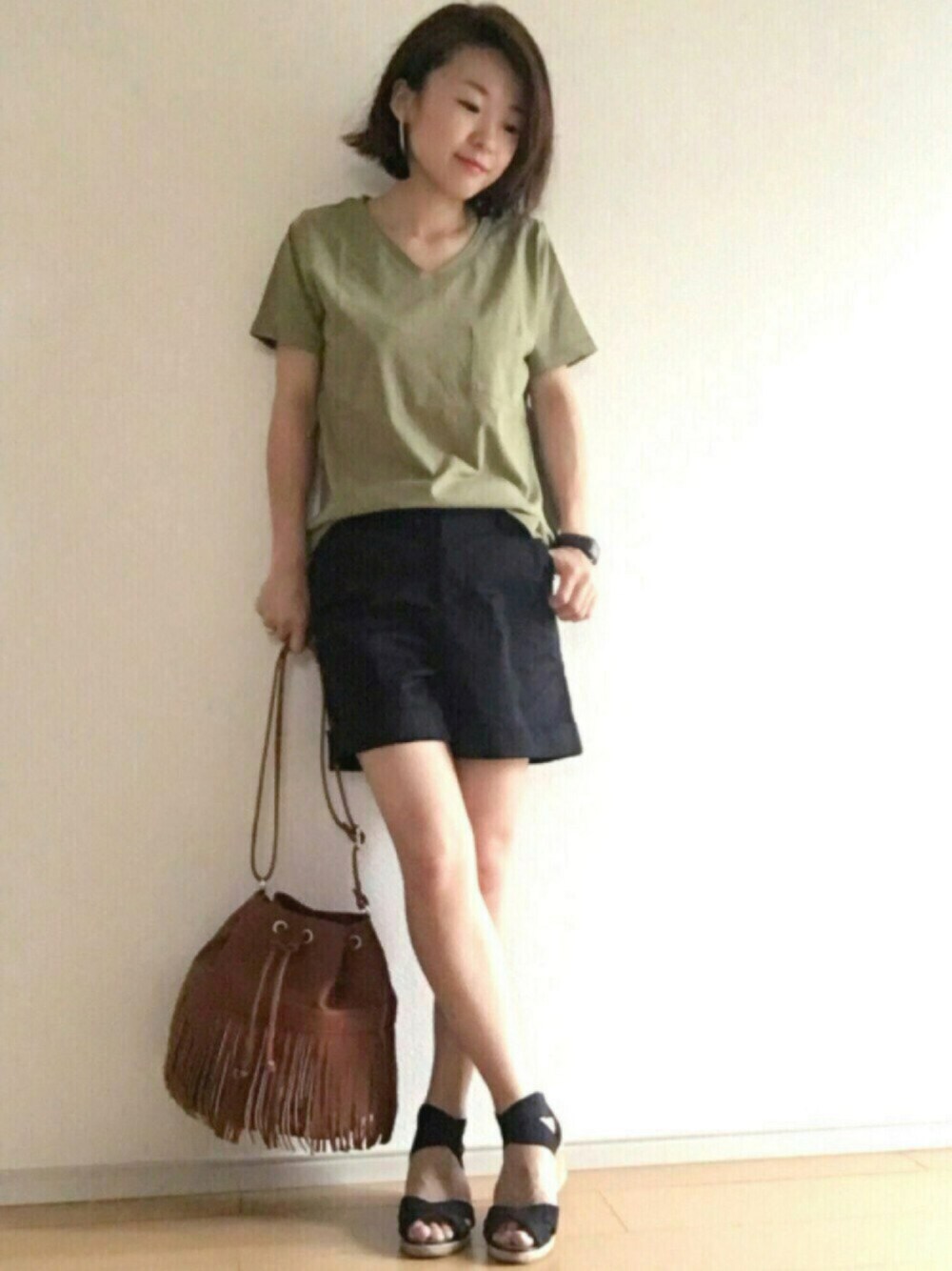 グリーン系のTシャツ/カットソー、ブラック系のパンツ、ブラウン系のバッグを着用したレディースの夏コーディネートの1枚目の写真
