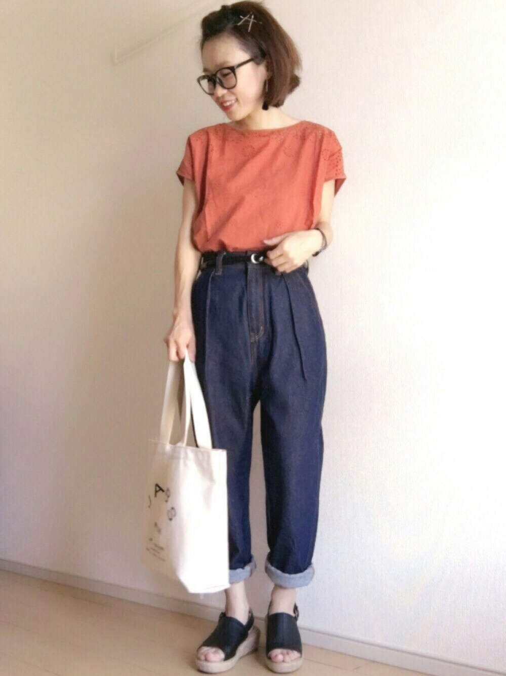 オレンジ系のTシャツ/カットソー、ブルー系のデニムパンツ、ブラック系のサンダルを着用したレディースの夏コーディネートの1枚目の写真
