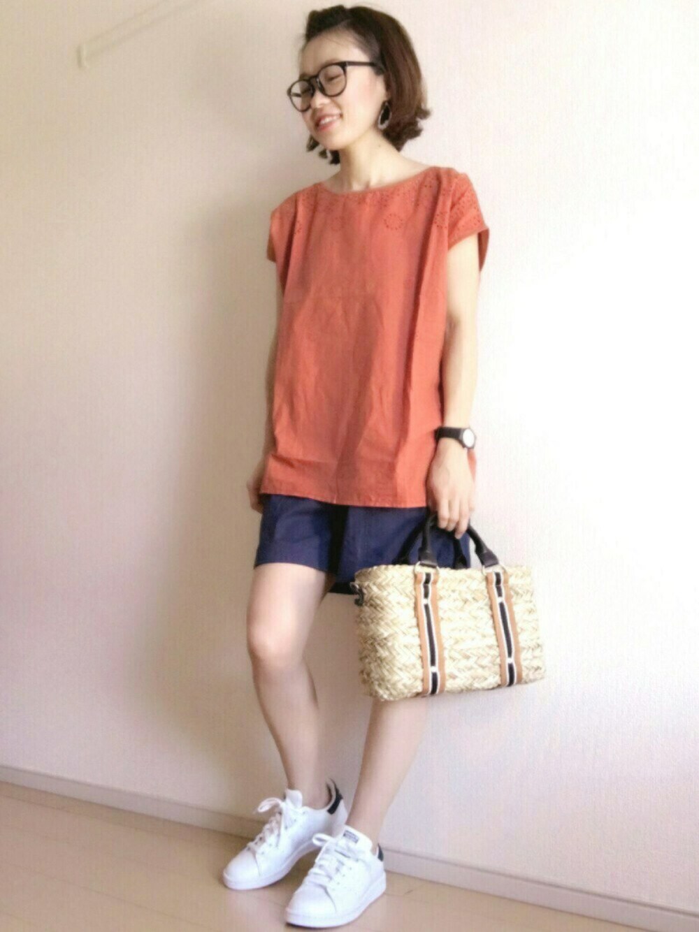オレンジ系のTシャツ/カットソー、イエロー系のかごバッグ、ホワイト系のスニーカーを着用したレディースの夏コーディネートの1枚目の写真