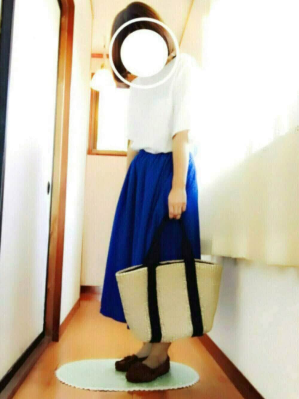 ブルー系のスカート、ホワイト系のTシャツ/カットソー、ブラウン系のモカシン/デッキシューズを着用したレディースの春コーディネートの1枚目の写真