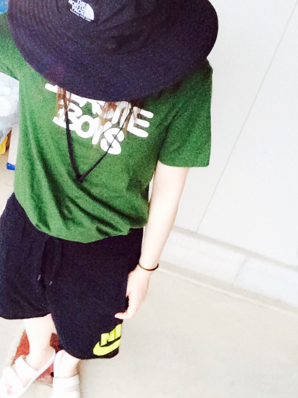 グリーン系のTシャツ/カットソー、ブラック系のパンツ、ホワイト系のサンダルを着用したレディースの夏コーディネートの1枚目の写真