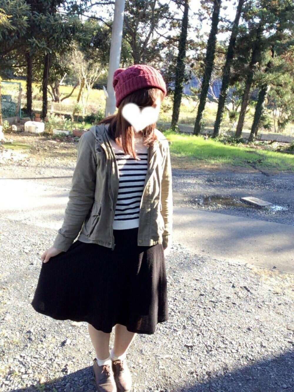 グリーン系のミリタリージャケット、ブラック系のニット/セーター、ブラック系のスカートを着用したレディースの秋コーディネートの1枚目の写真