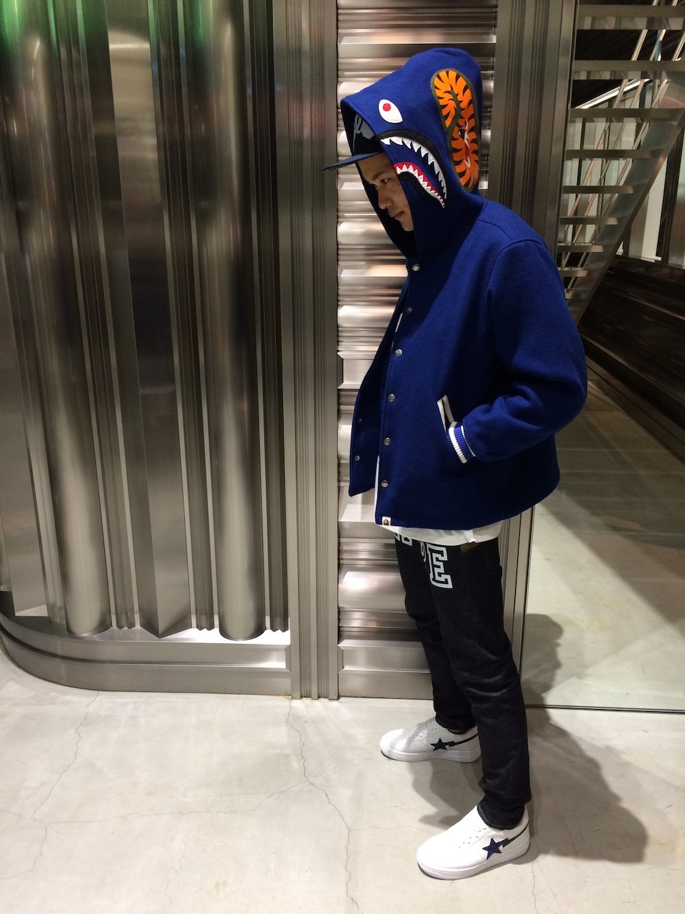 「ジャケット、デニム、レオパード、キャップ、オーバーサイズ、白スニーカー、A BATHING APE、Bape、白Tシャツ」｜「A BATHING APEのSHARK VARSITY JACKET（スタジャン、ブルー系）」を使った、児玉 洋介さん（メンズ・176cm）の秋コーディネートの1枚目の写真