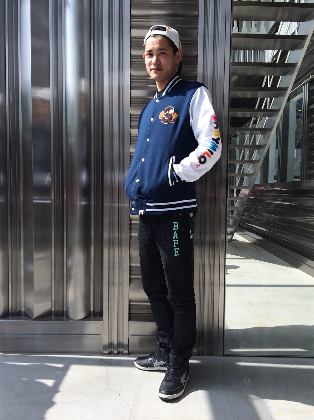 「ストリート、A BATHING APE、ハイカットスニーカー、ブラックデニム、Bape、キャップ後ろかぶり、スエットジャケット」｜「A BATHING APEのCITY CAMO BLACK SLIM DENIM（デニムパンツ、ブラック系）」を使った、児玉 洋介さん（メンズ・176cm）の春コーディネートの1枚目の写真