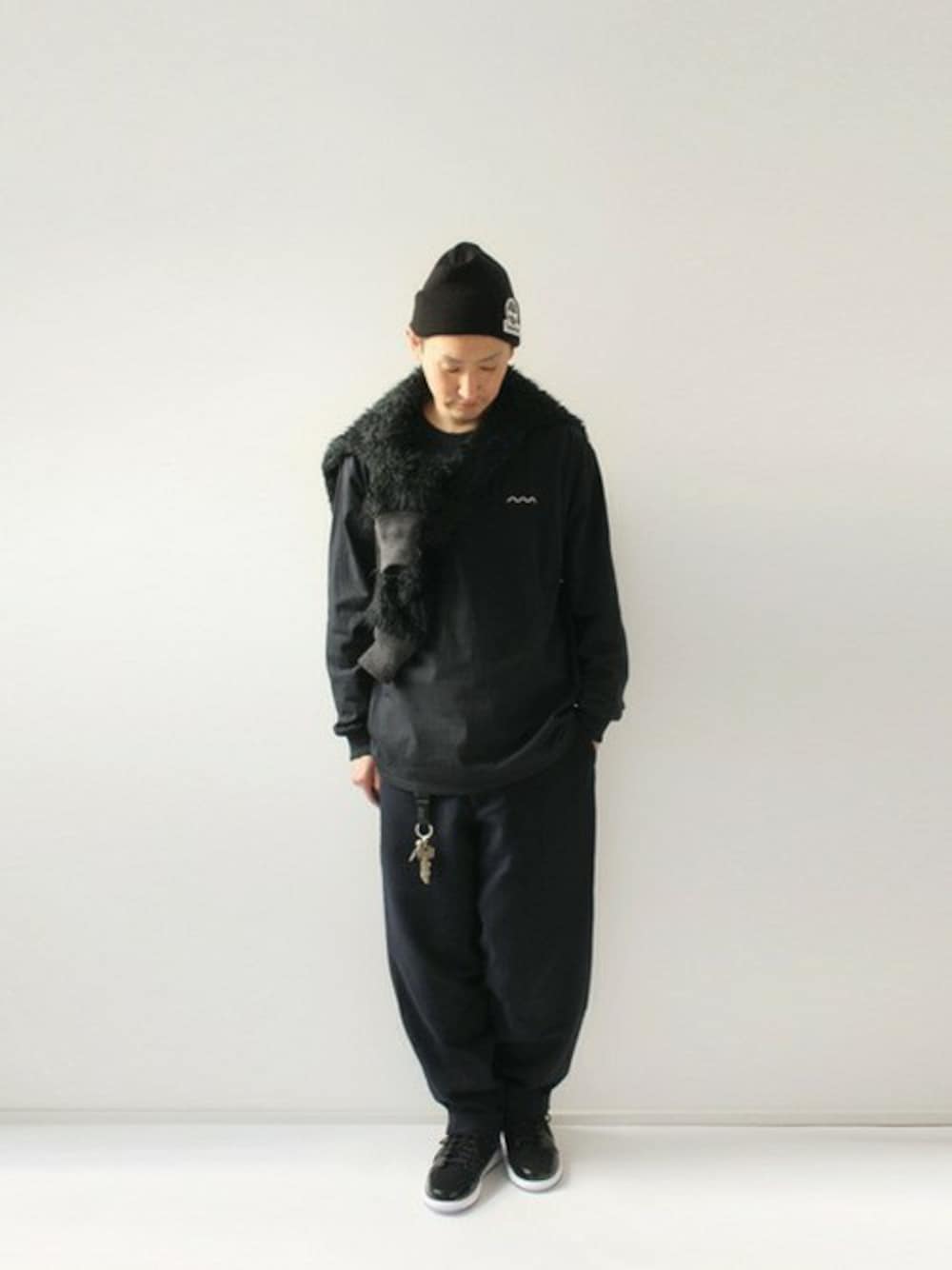 ブラック系のノーカラージャケット、ブルー系のその他パンツ、ホワイト系のスニーカーを着用したメンズの冬コーディネートの1枚目の写真