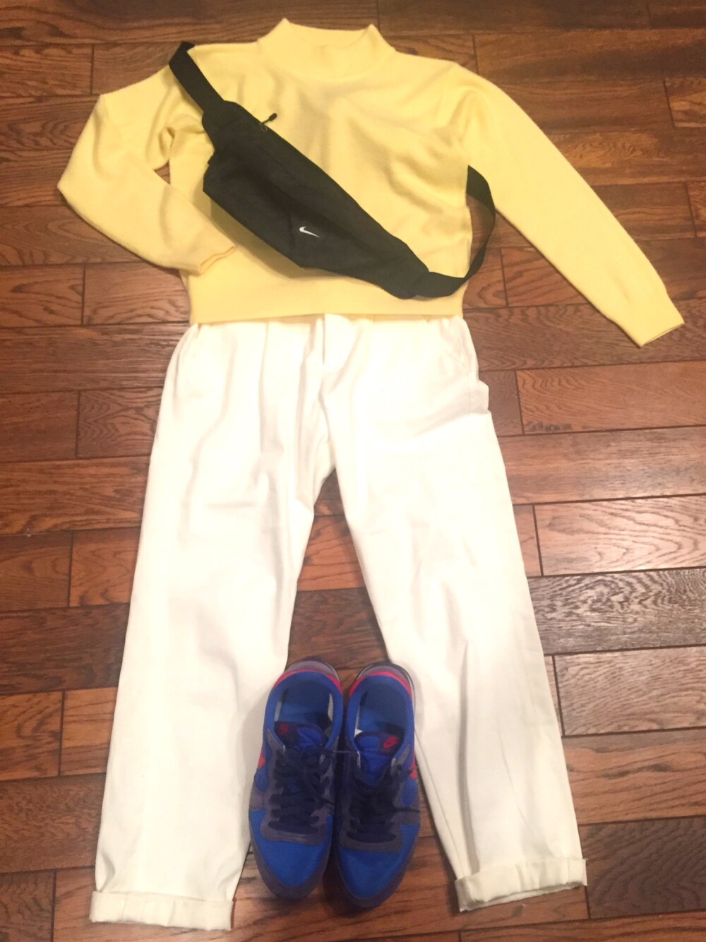 イエロー系のニット/セーター、ホワイト系のパンツ、ブルー系のスニーカーを着用したレディースの春コーディネートの1枚目の写真